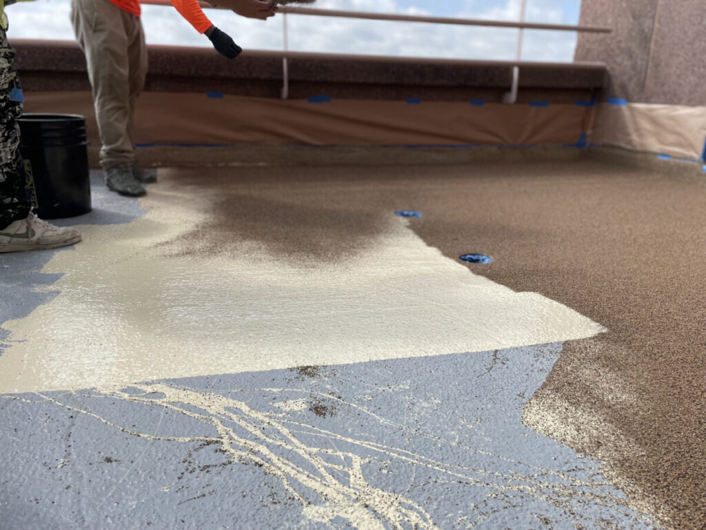 Resurfaced concrete balcony with high-solids silicone coating and ceramic granules on Arlington high-rise by Pepper Coatings