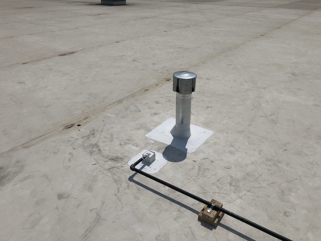 Completed pitch pan around gas pipe on commercial roof at Oakhollow Business Park, Arlington, Texas