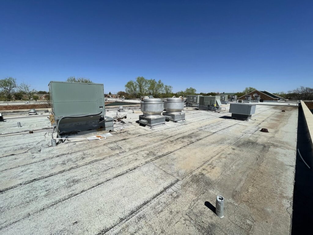 Weathered commercial flat roof with rooftop mechanical units during a free roof inspection in Abilene, TX