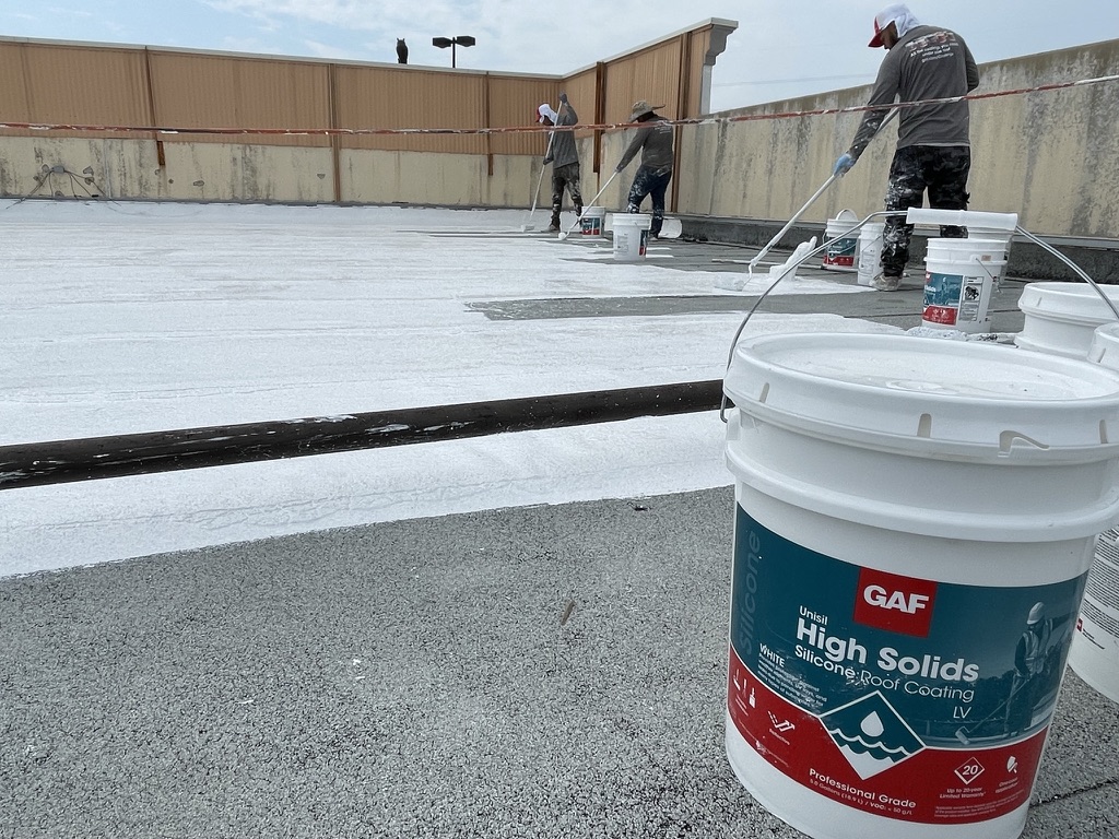 Commercial roof restoration with elastomeric coating showing the finished reflective surface
