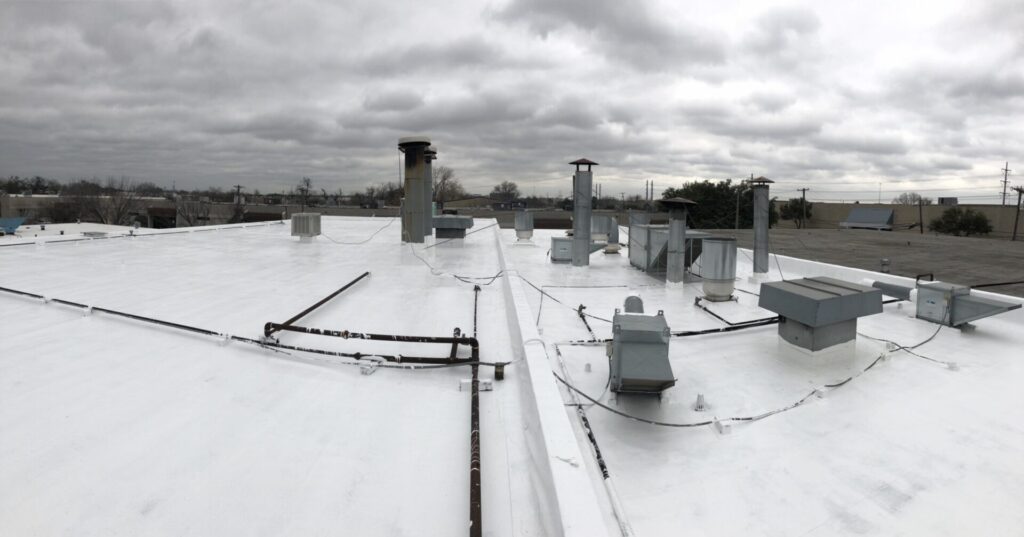 White silicone fluid applied roofing system going down over the Mod-Bit roof, Dallas, TX
