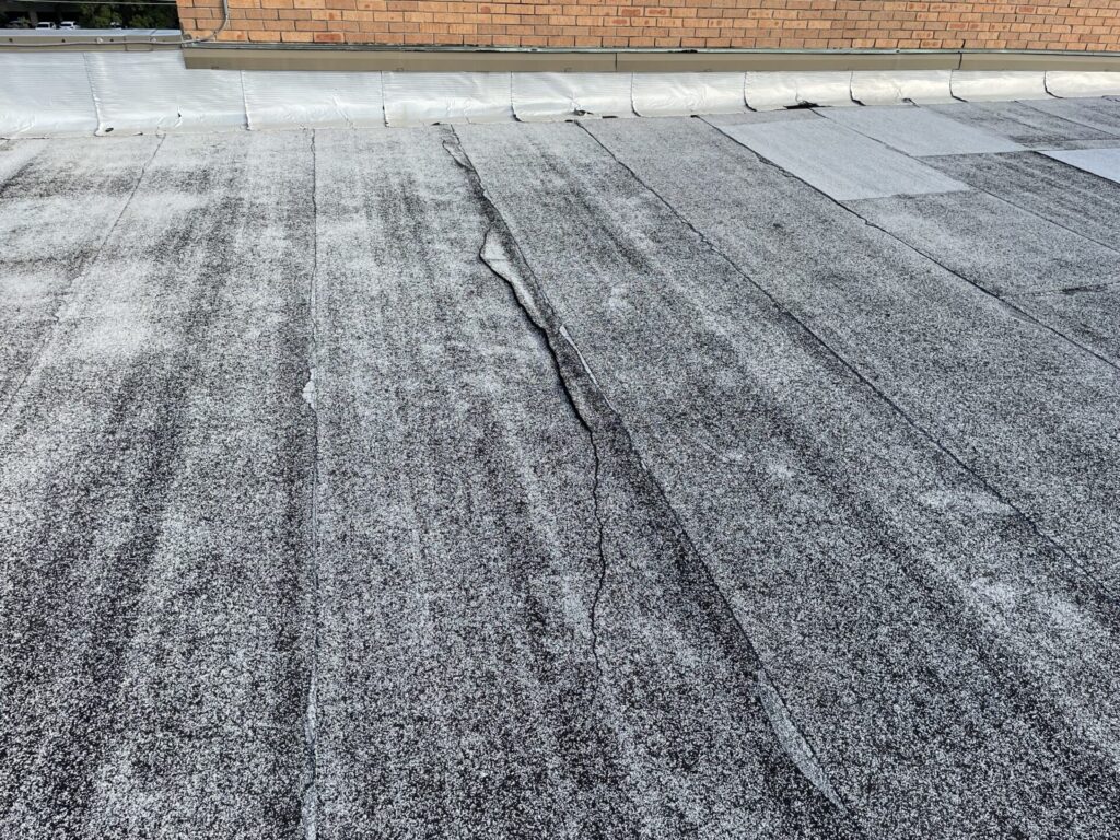 Silicone mastic sealing failed Mod-Bit seams and a long fracture in the membrane, Alpha Rd, Dallas