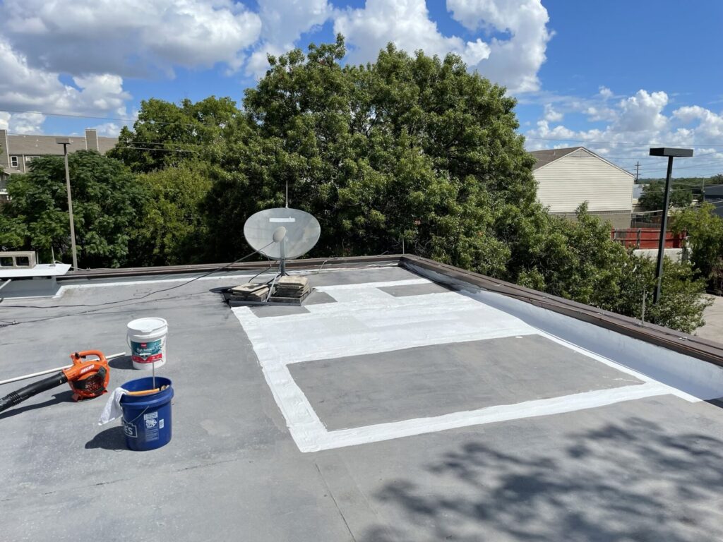 Completed pitch pan repair with granules broadcast into the silicone coating to conceal the patch, Dallas, TX