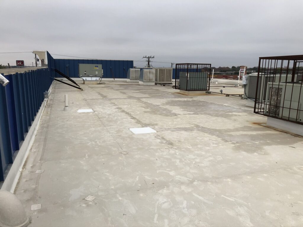 Silicone roof coating over a TPO flat roof at the S. Hampton Rd. retail center in the Redbird area of Dallas, TX