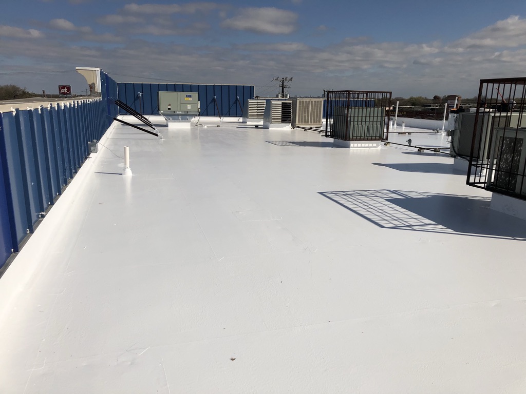 Finished white silicone roof coating on the commercial flat roof at S. Hampton Rd., Dallas, TX
