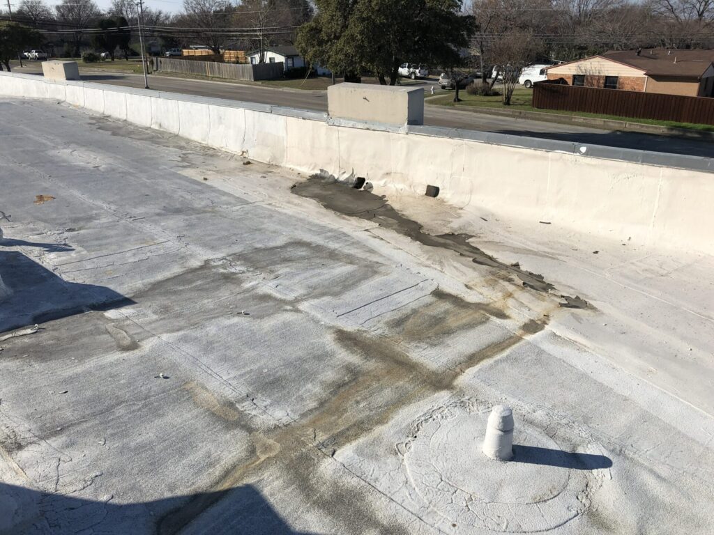 Delaminated acrylic roof coating over a Modified Bitumen roof at 14024 Josey Ln, Dallas, TX