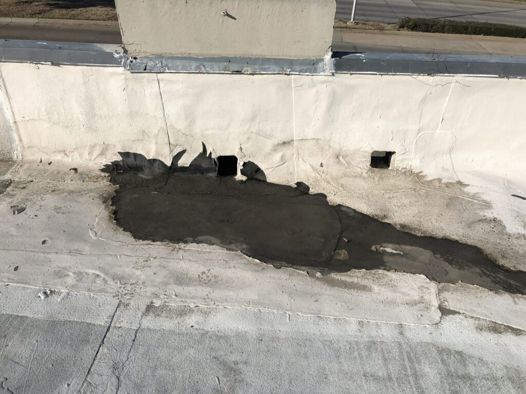 Acrylic coating broken down by ponding water on a flat low-slope commercial roof in Dallas