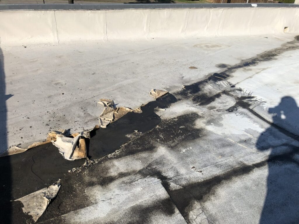 Damage beneath an RTU condensate drip showing rapid coating delamination, Josey Ln, Dallas