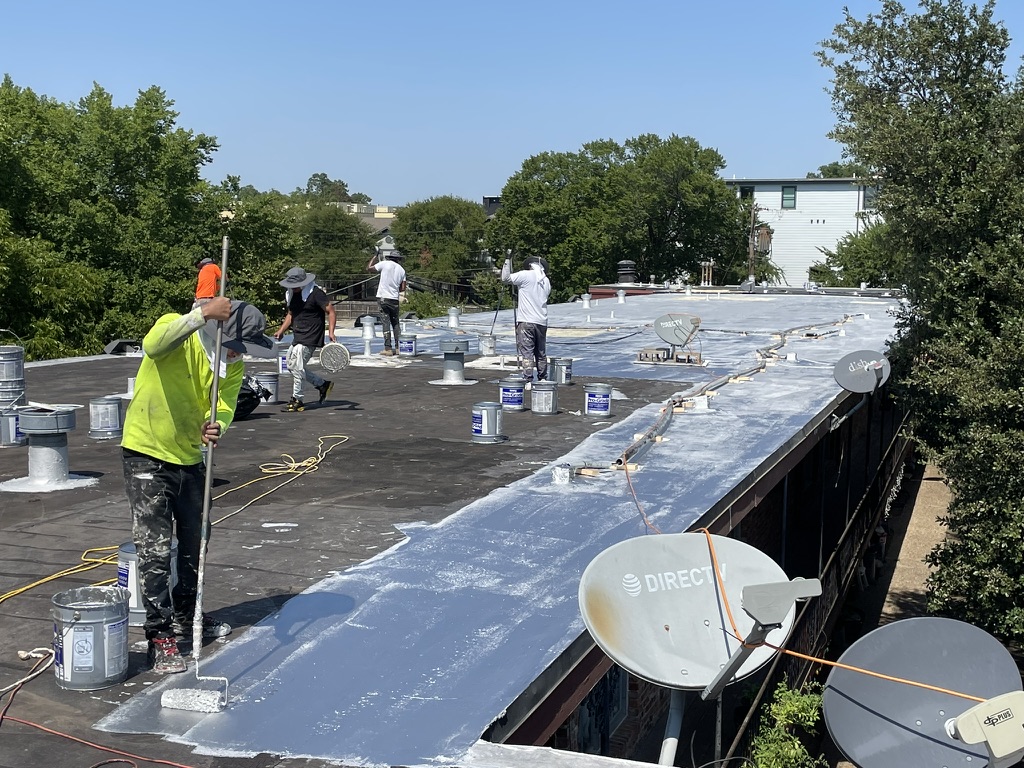 Roof coating application in progress across the multifamily deck at 4607 Monarch St, Dallas