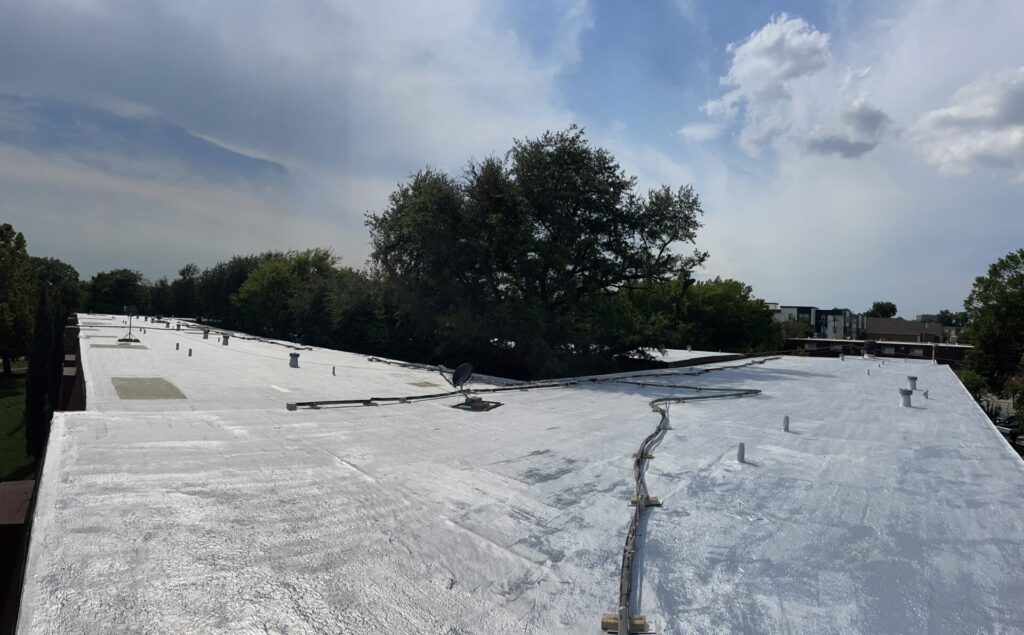 Completed 44,000 sq ft roof coating restoration on the Dallas multifamily property, bright reflective surface