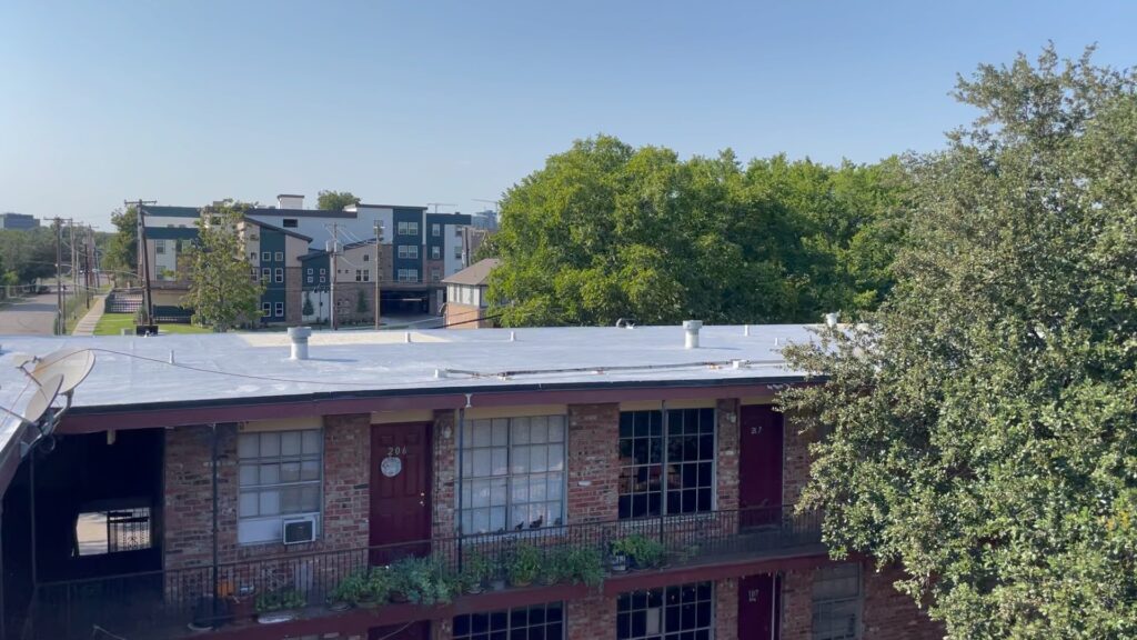 The 44,000 sq ft multifamily property at 4607 Monarch St in Dallas, showing the flat bitumen roof above the brick building