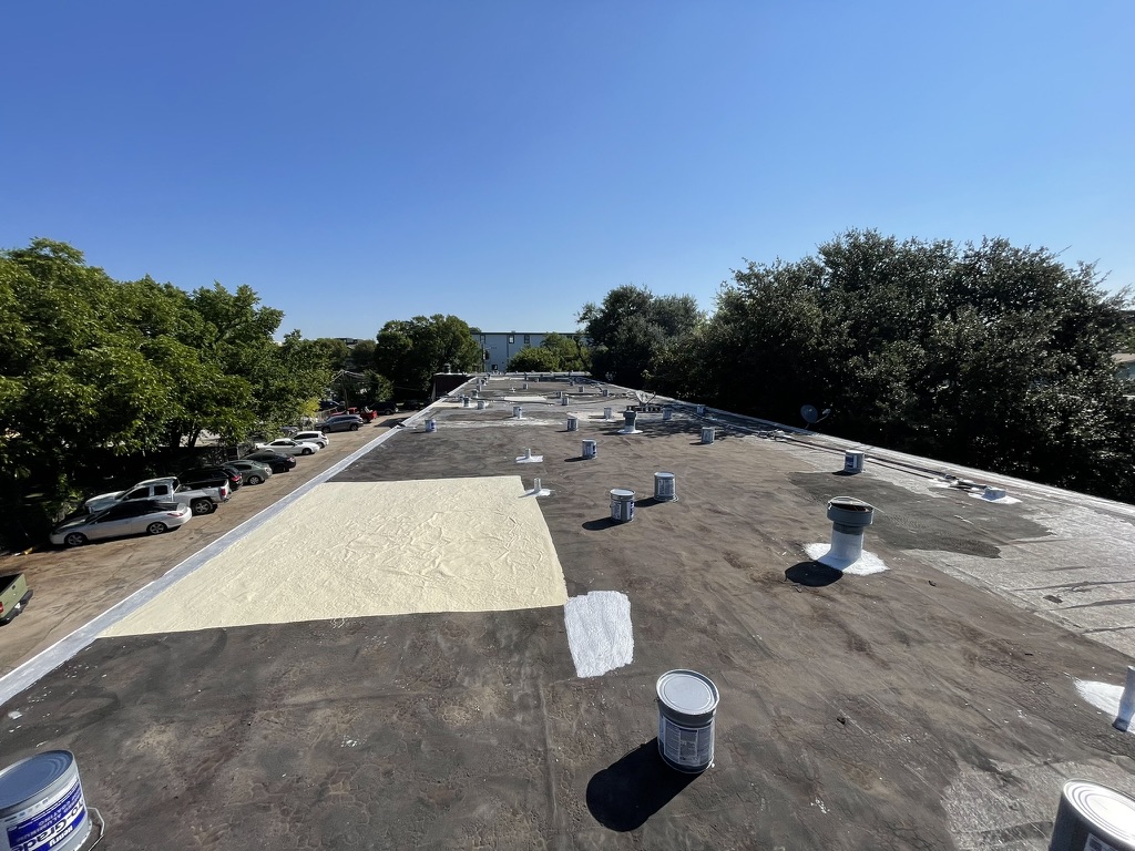 Detail prep work at a roof penetration on the multifamily bitumen roof in Dallas, Texas