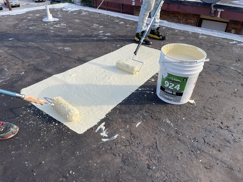 Mastic worked into seams and existing patch repairs ahead of the coating application, Monarch St, Dallas