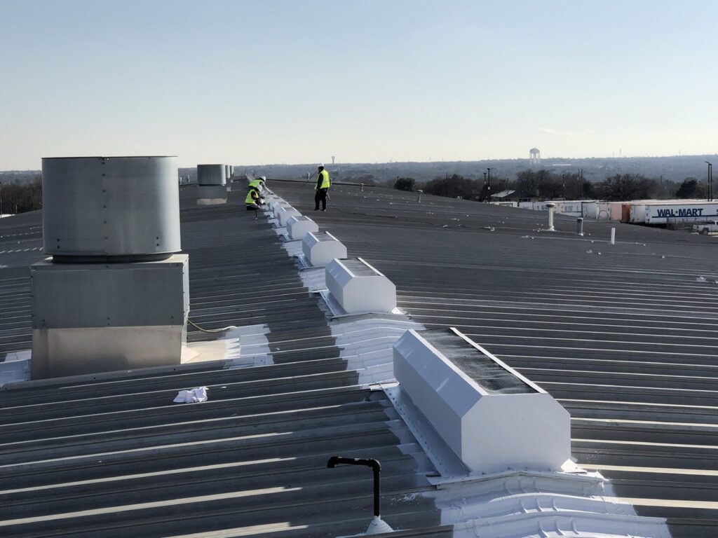 Pepper Coatings crew coating seams and vents on the standing-seam metal roof of the Walmart Distribution facility in DeSoto, TX