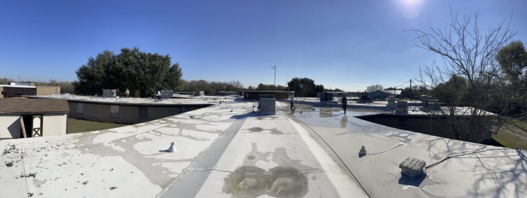 Silicone mastic detail work at field seams and RTU curb transitions on the 27,000 sq ft TPO roof in Ennis, Texas