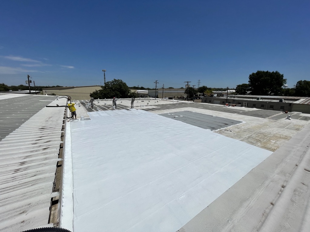 Silicone mastic applied at damaged locations and penetrations on the commercial Mod-Bit roof in Ennis, Texas