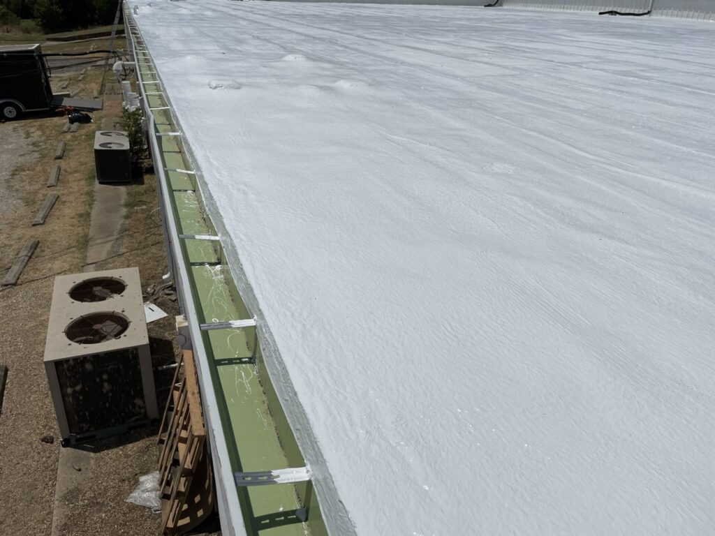Silicone roof coating application over the 10,000 sq ft flat Mod-Bit office section, Ennis, TX