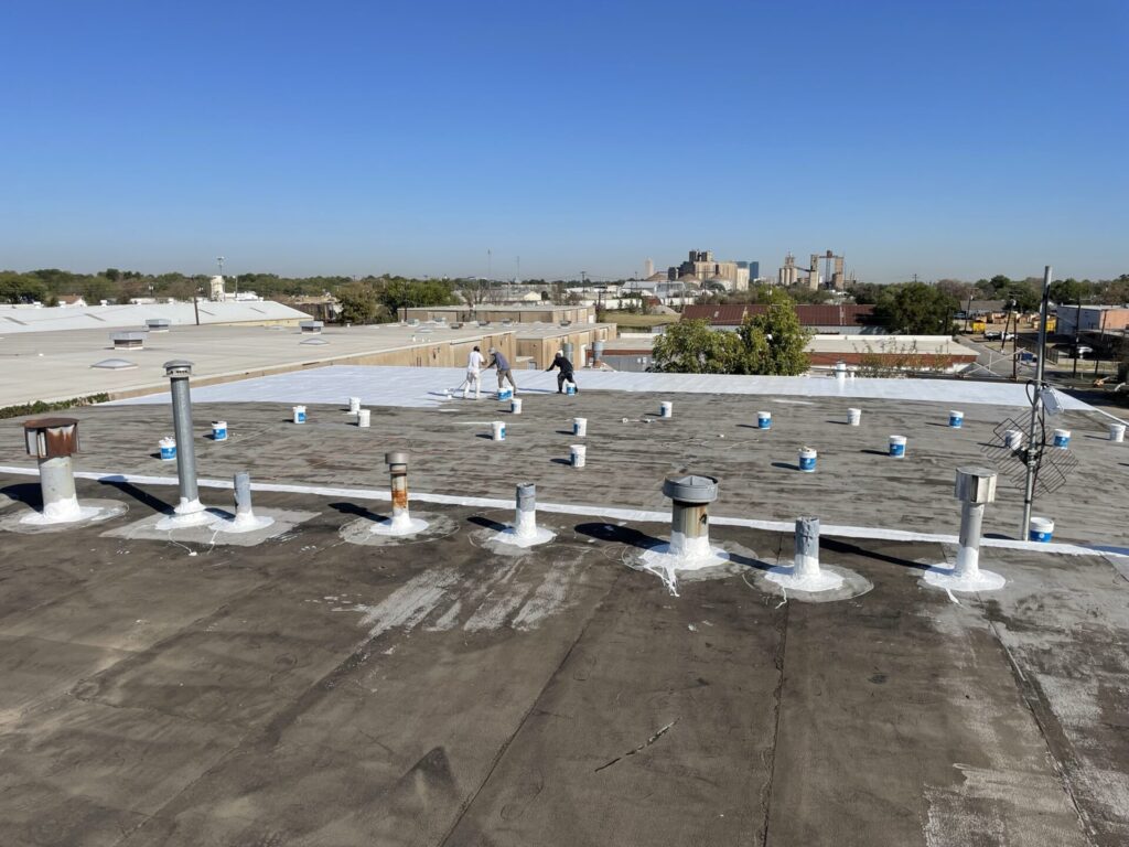 Silicone roof coating in progress across the four-assembly roof complex in the South Main Street Commercial Zone, Fort Worth