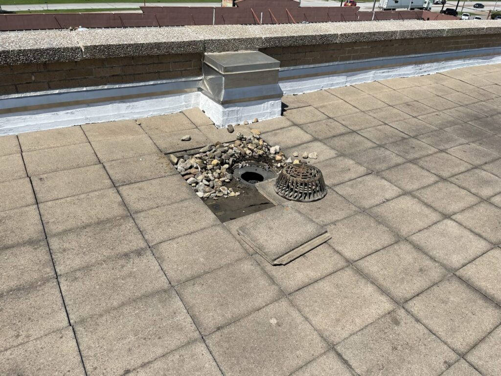 EPDM membrane exposed after removing concrete tiles for roof leak repair at AT&T property, Grand Prairie, TX