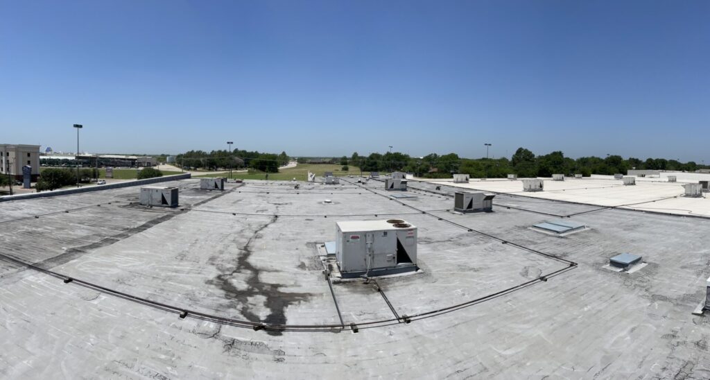 Silicone roof coating application over Modified Bitumen at Greenville Promenade strip center, Greenville, TX