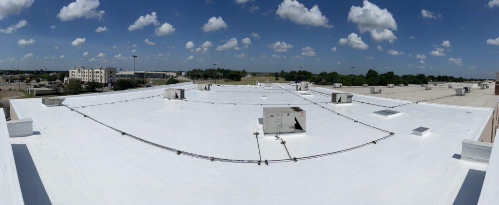 Completed silicone roof coating at Greenville Promenade — bright white reflective finish, Greenville, Texas