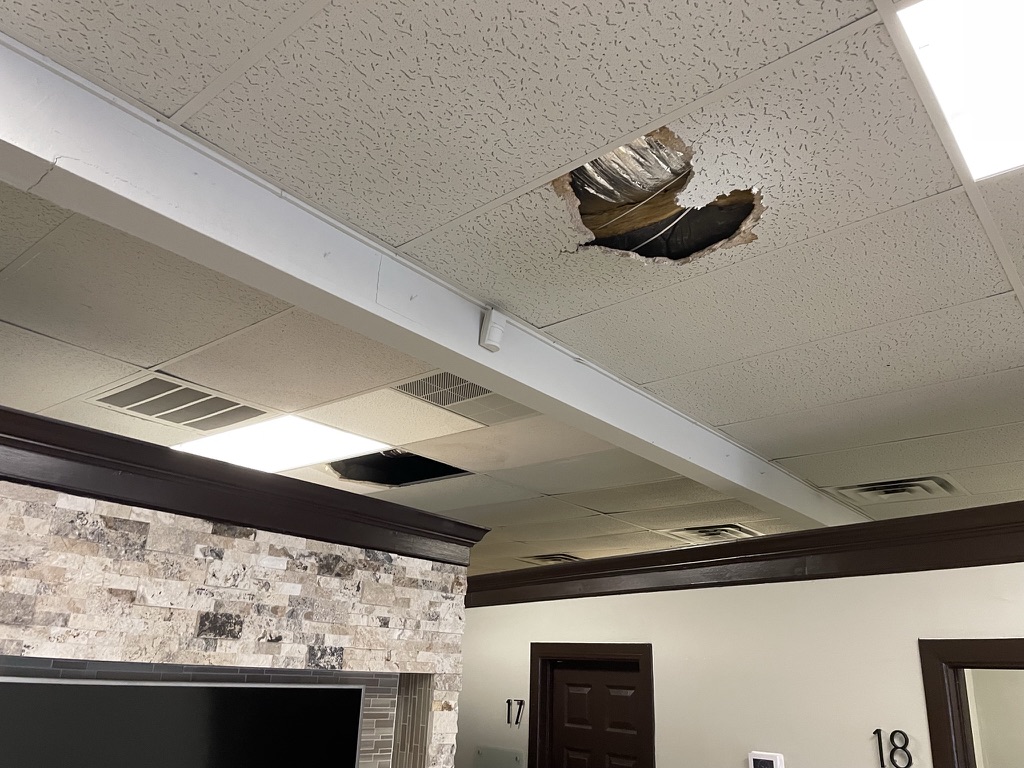Flat roof leak repair in progress at Melbourne Place commercial strip center in Hurst, TX
