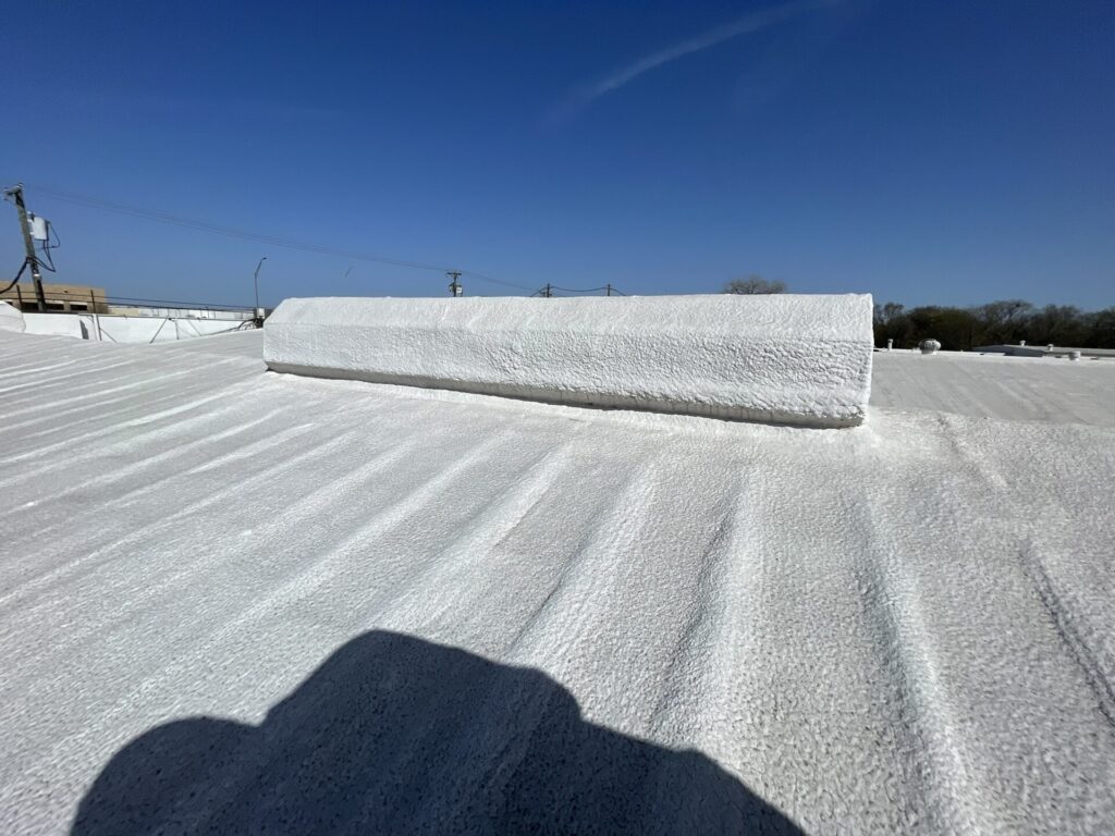 Acrylic roof coating application over the sprayed polyurethane foam substrate in Lancaster, Texas
