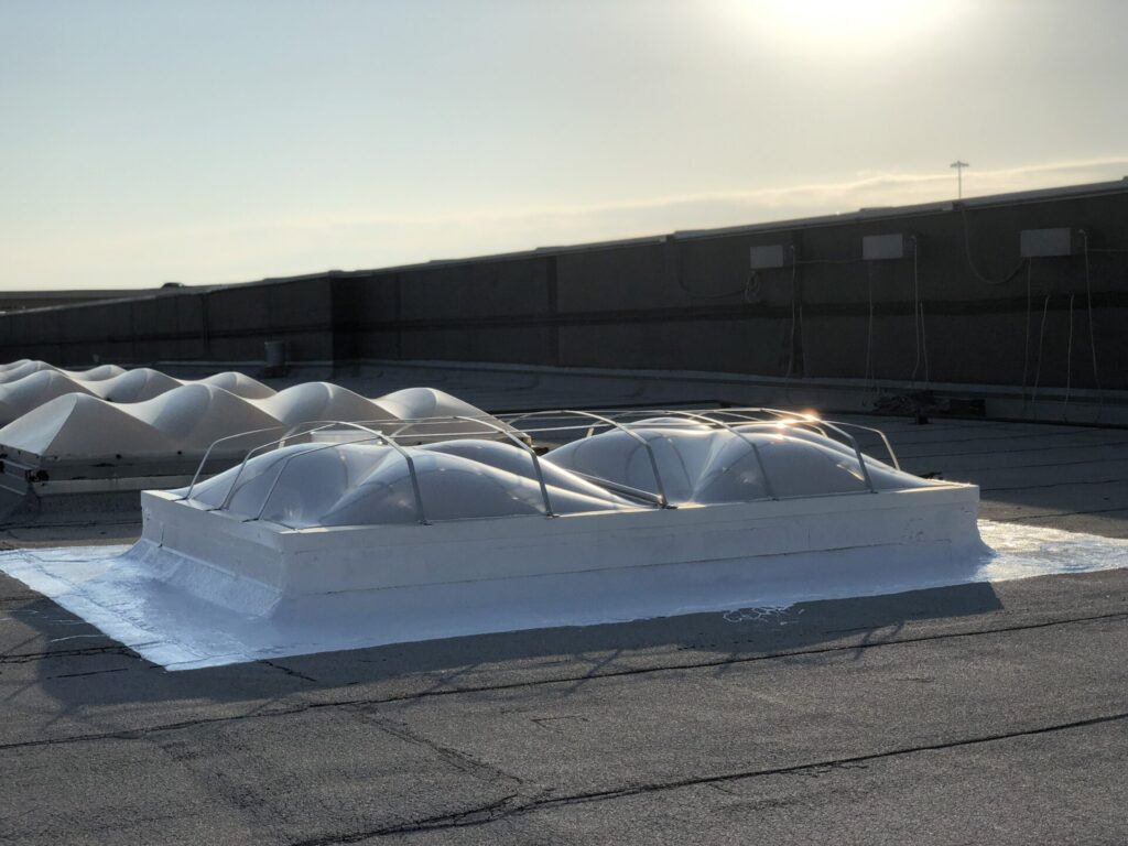 Completed silicone roof coating over the repaired skylight curb at LA Fitness, Lewisville, TX