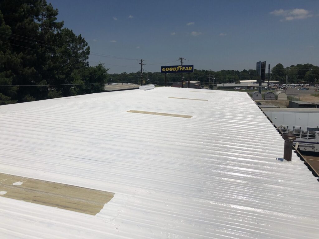 Completed white silicone roof coating over the 7,500 sq ft R-panel roof at GoodYear Tire, Longview, TX