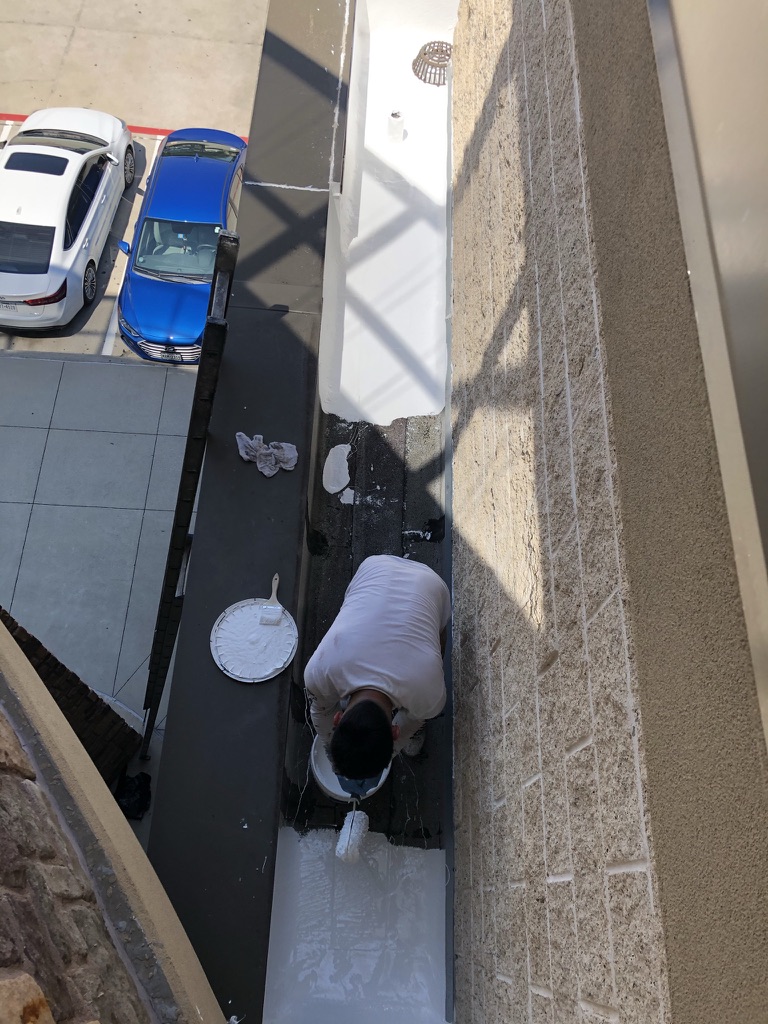 Power washing affected roof areas before silicone coating application at LA Fitness in McKinney, Texas