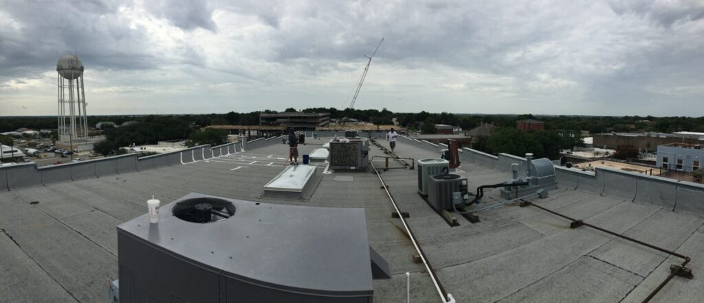 Hail-damaged Modified Bitumen roof at The Tom Day Co., 211 E Louisiana St on the historic McKinney square