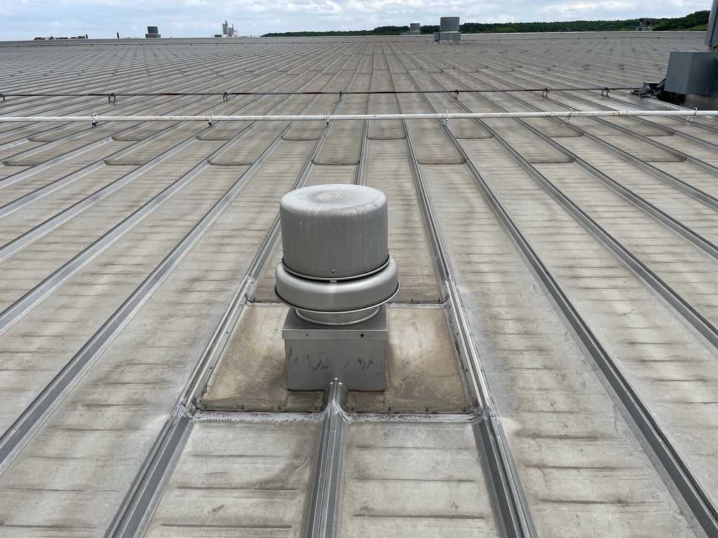 Roof vent and standing-seam metal panels on a commercial facility in Midlothian, Texas