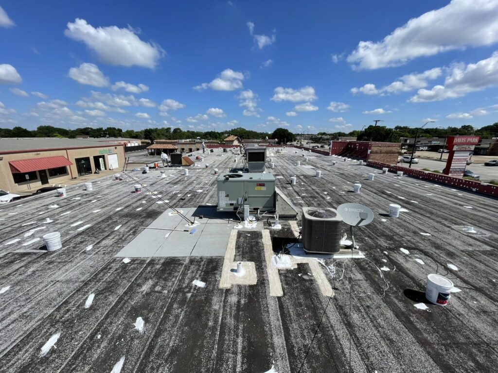 Silicone roof coating application in progress on 13,000 sq ft flat roof, North Richland Hills, TX