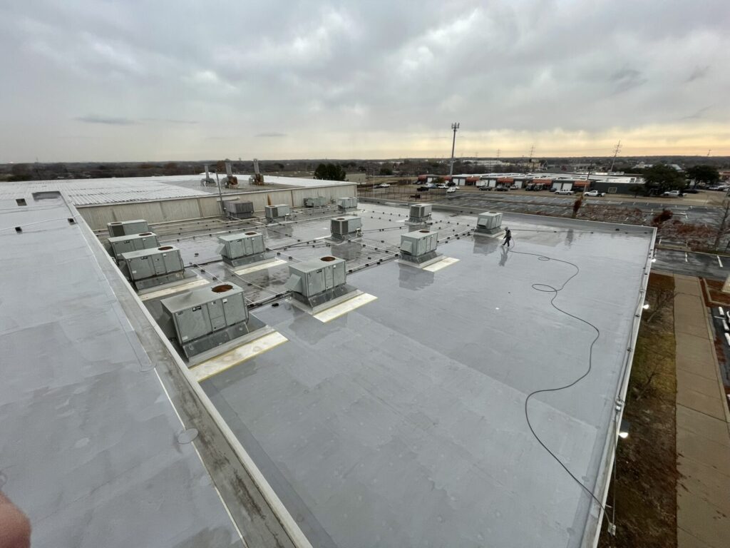 Silicone roof coating over flat TPO roof at 6625 Iron Horse Blvd, North Richland Hills, TX