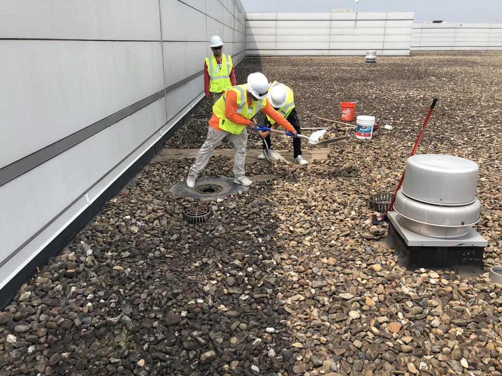 Ballast pulled back from the EPDM membrane to access a failing roof drain at the Kimberly-Clark facility in Paris, TX