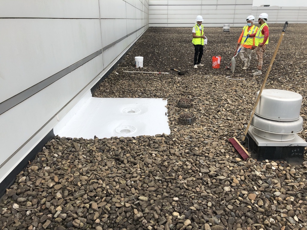 Silicone mastic worked into the roof drain assembly on the 1,300,000 sq ft industrial facility in Paris, TX