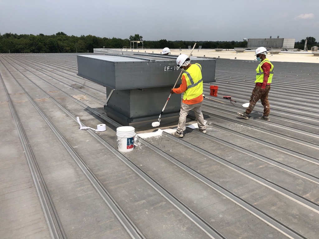 Affected roof areas cleaned with broom and wire brush before the 3-course silicone application