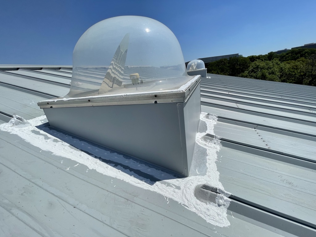 Silicone mastic sealing the skylight dome to the frame on the 42,000 sq ft service building, Plano, TX