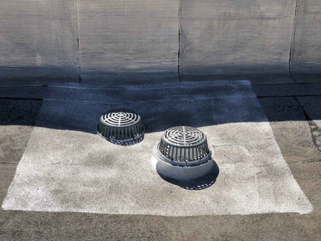 Silicone mastic applied into a commercial roof drain during leak repair in Princeton, Texas
