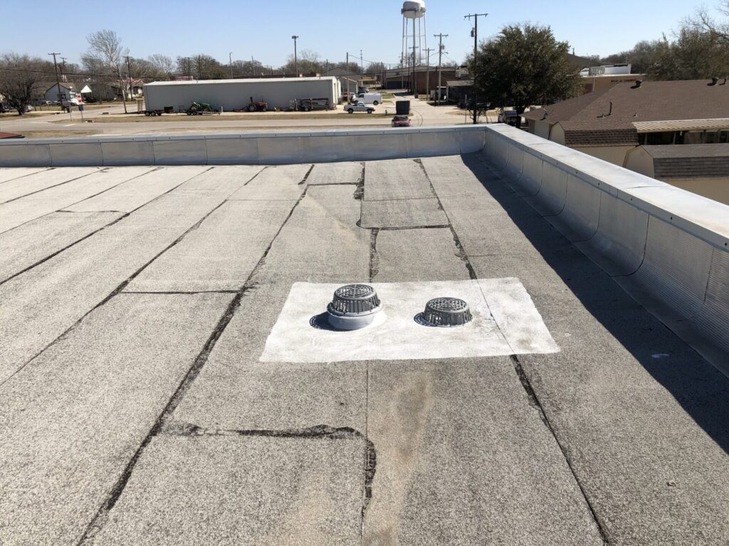 Three-foot silicone coated perimeter around a repaired roof drain on the AT&T commercial flat roof, Princeton, TX