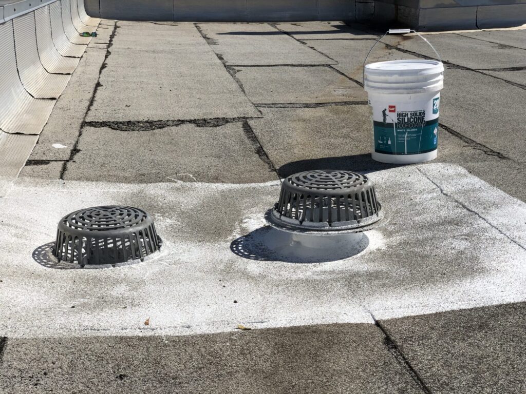 Completed silicone roof drain repair — one of 8 drains sealed on the Mod-Bit roof at 211 McKinney Ave, Princeton