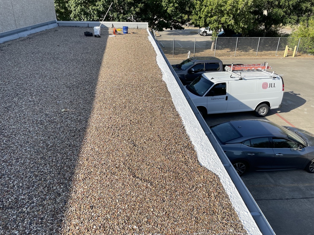 Silicone roof coating sealing drip edge cracking on the commercial warehouse roof at N Greenville Ave and E Main St, Richardson