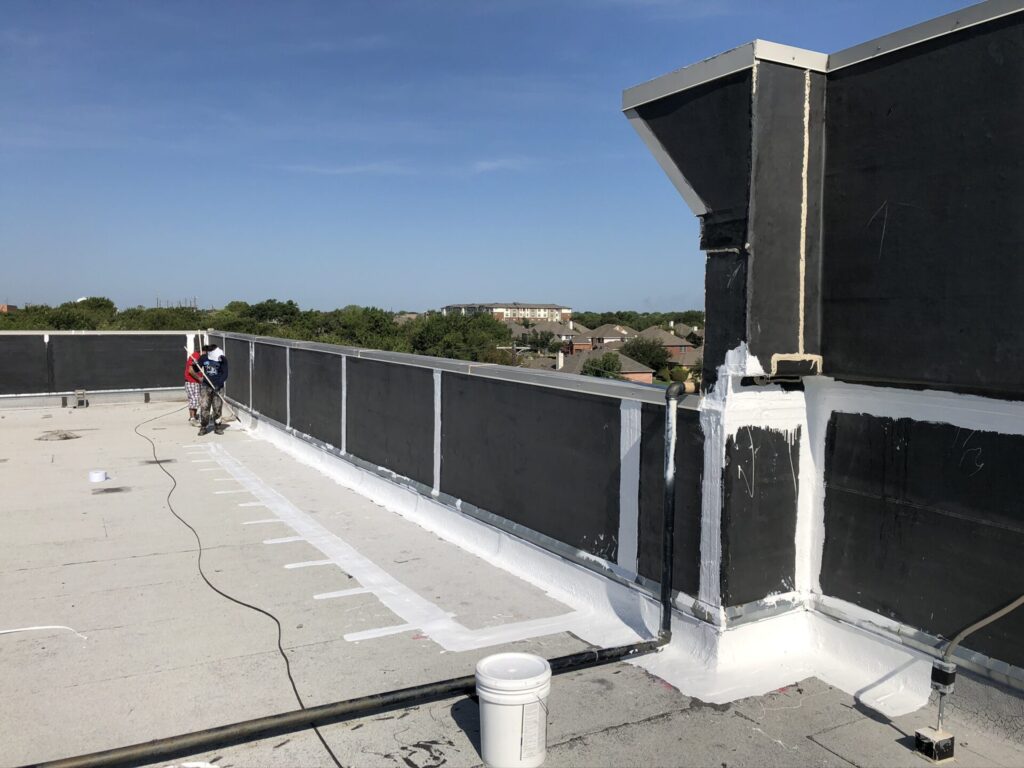 Flood coat silicone roof coating applied over Mod-Bit sections near the parapet wall at LA Fitness, Rowlett, TX