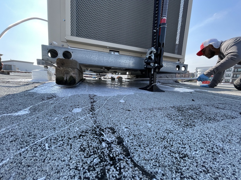 Silicone roof coating application in progress at Timberlake Shopping Center, Rowlett, Texas