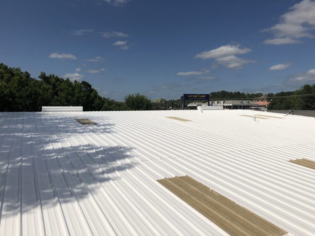 Completed white silicone roof coating over the 11,500 sq ft rusted R-panel roof at GoodYear Tire, Tyler