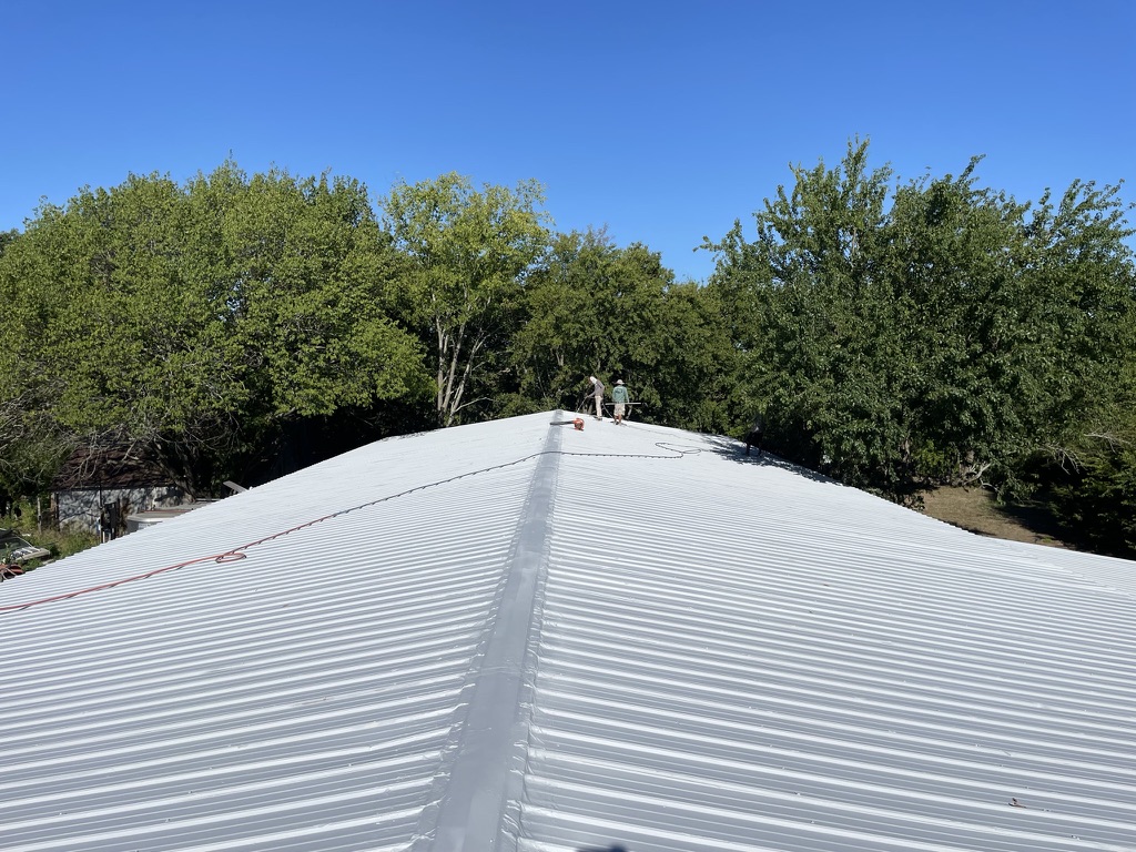 Completed gray acrylic roof coating system on the pitched R-panel roof in Van Alstyne, Grayson County, TX