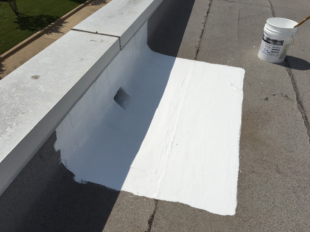 Silicone mastic applied into a scupper drain during commercial roof leak repair in Allen, Texas