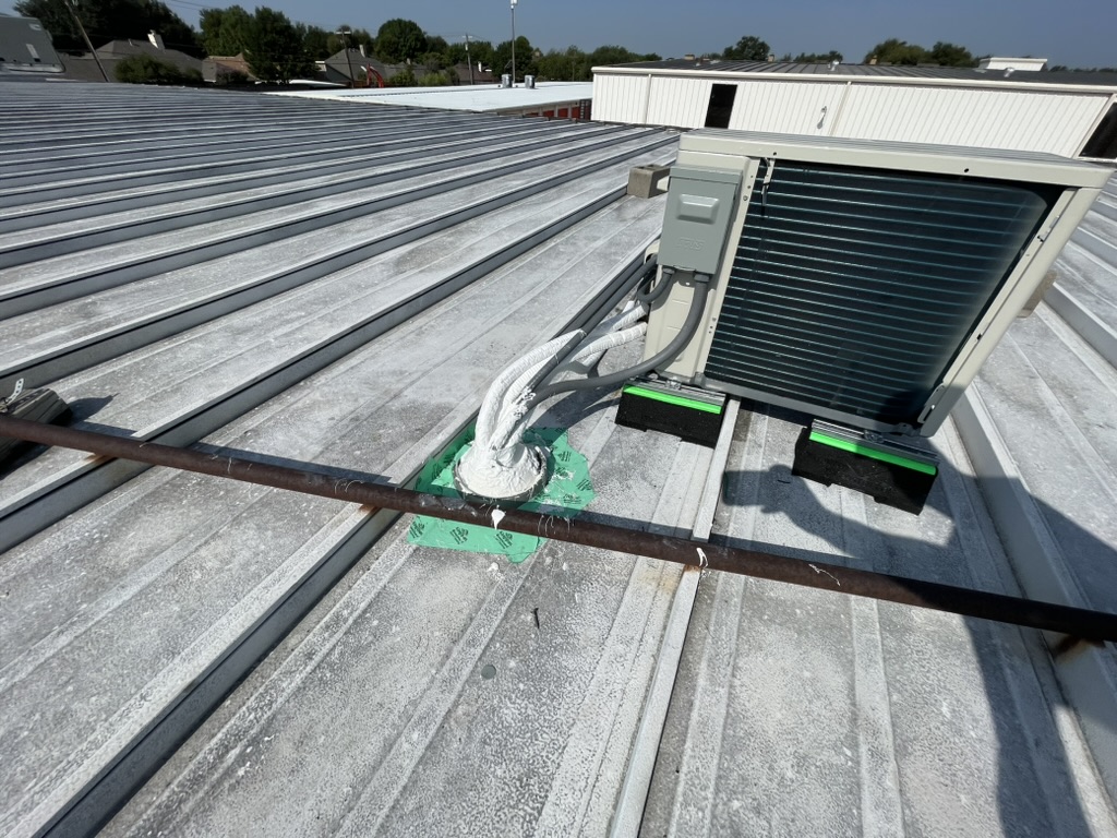 Mini split condensation draining directly onto an acrylic coated metal roof, Trinity Mills Rd, Carrollton, Texas