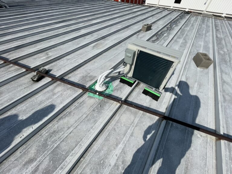 Improperly dried-in mini split roof penetration sealed with tape on a commercial metal roof in Carrollton, TX