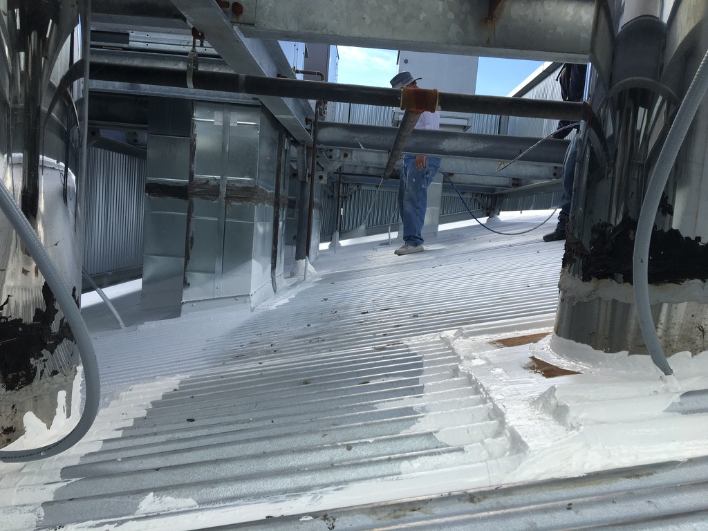 Dark grey Lapolla Thermo-Flex 1000 acrylic coating going down over the metal roof, Coppell, Texas